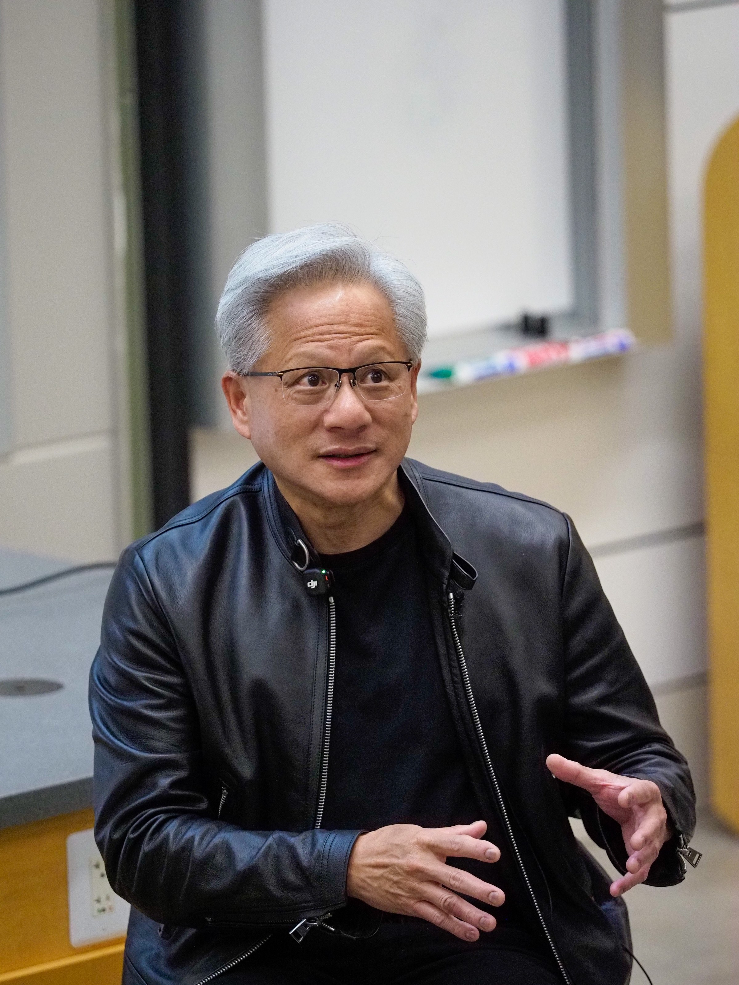 Jensen Huang, Nvidia's founder and chief executive, speaking in a lecture room at Stanford University, in a black leather jacket with a clip microphone.